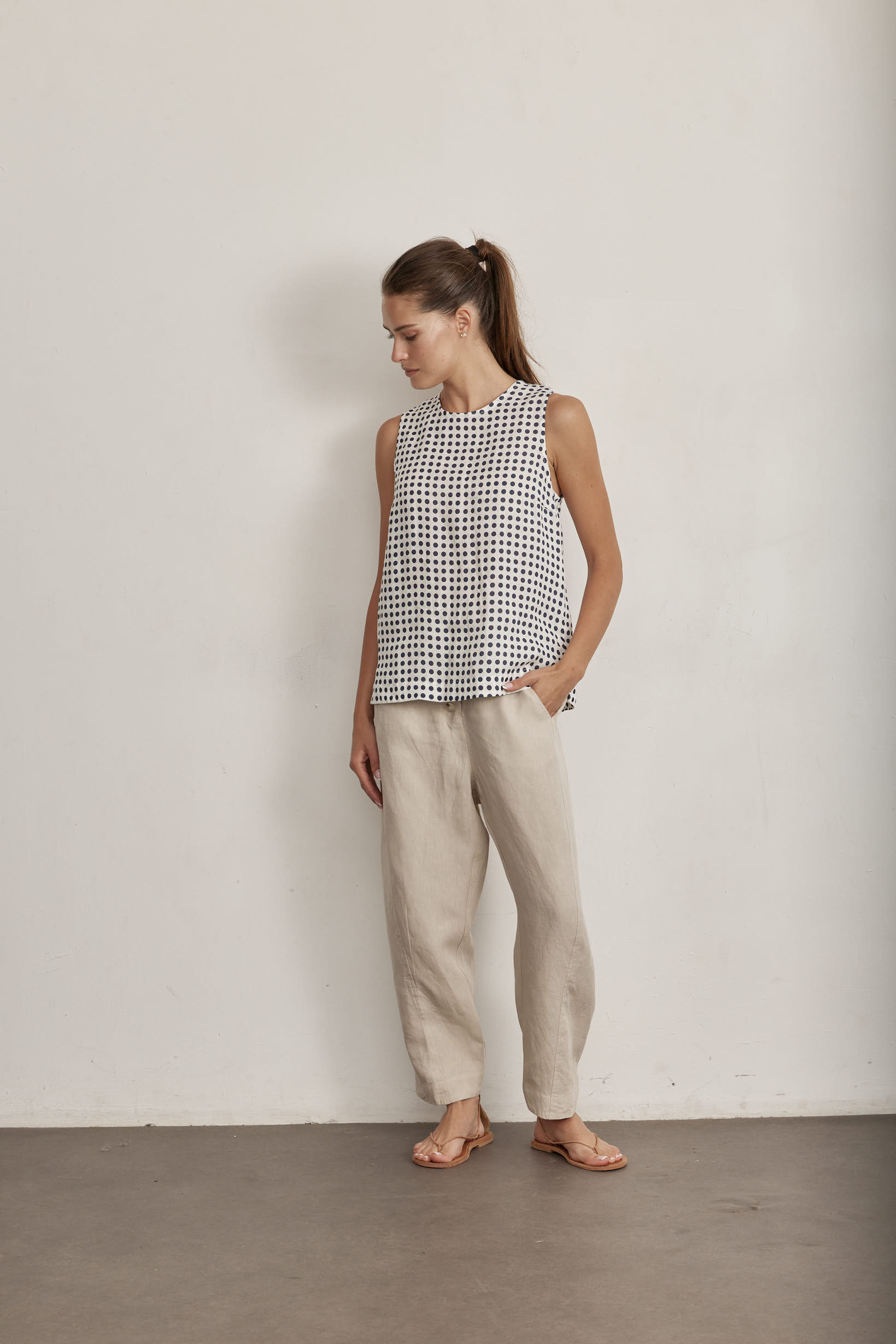 White sleeveless top with navy polka dot pattern