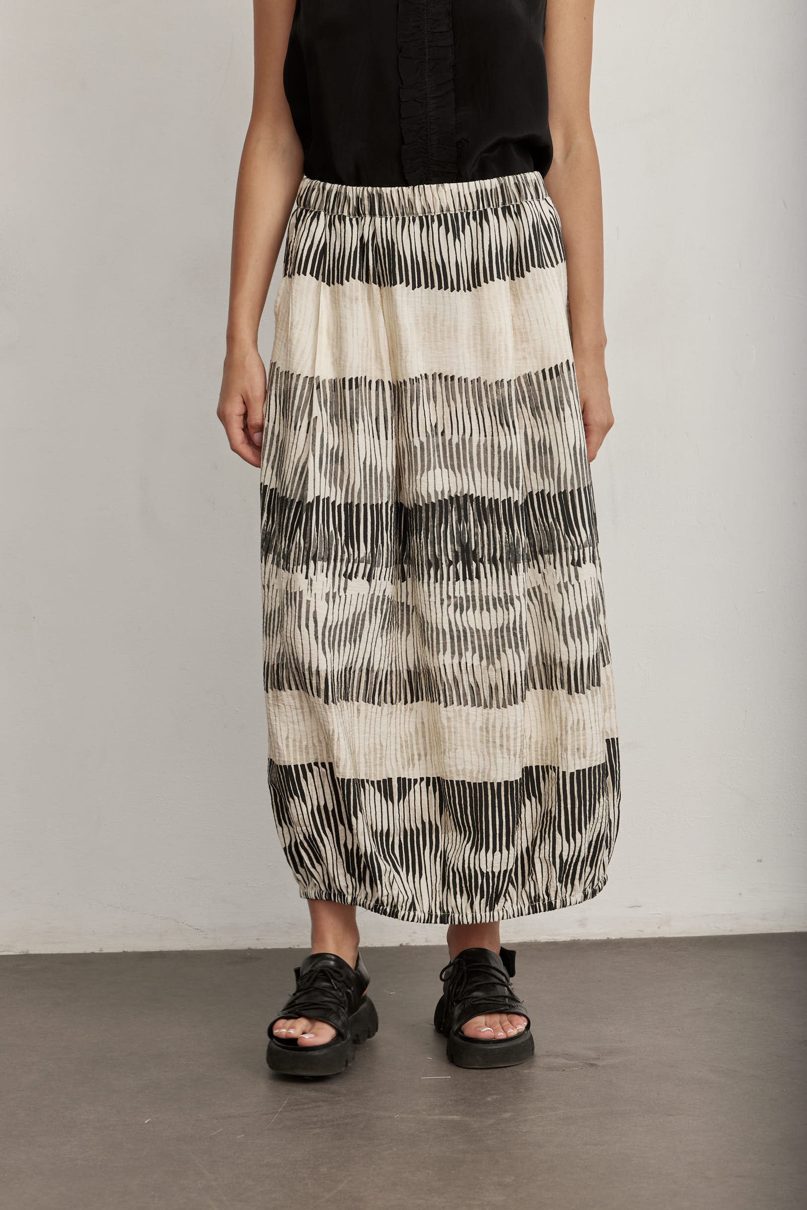 Black top with striped and pleated cream skirt